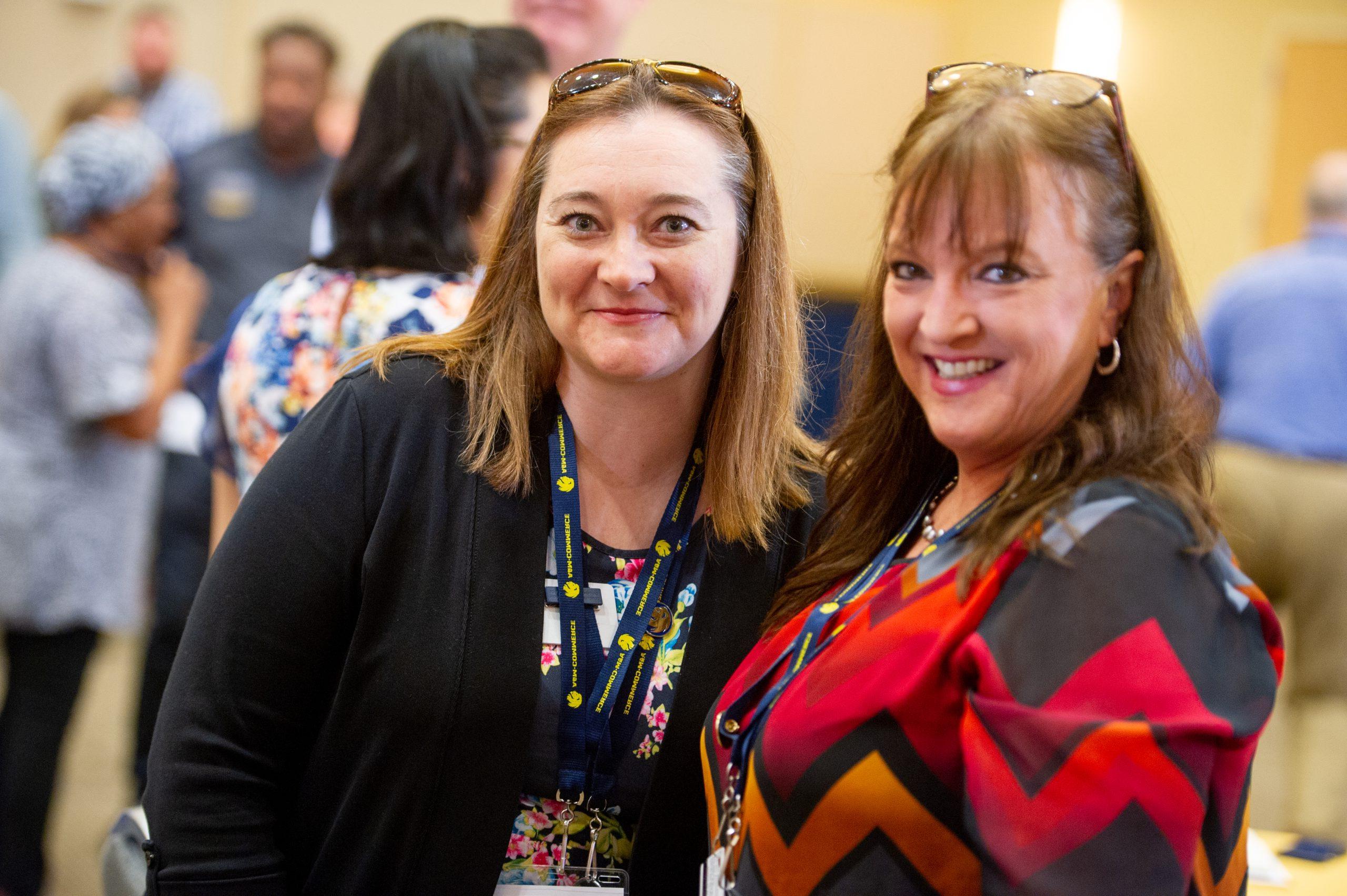 Two female smiling at the camera man.